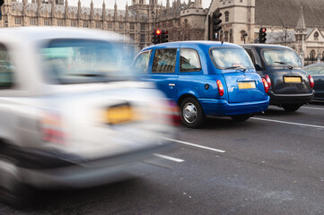 Tipycal London taxis waiting by the traffic light in front of Westminster
