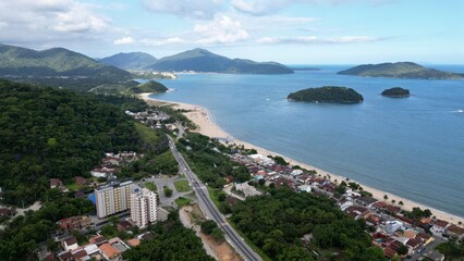 Fototapeta premium Linda vista aerea com drone sobre o mar com montanhas e cidade ao fundo com cores vibrantes.