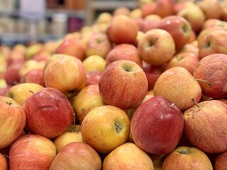 Box filled with fresh natural bio organic red yellow coloured apples placed on counter in local food market. Close-up