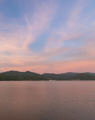 Beautiful sunset over a calm lake with mountains in the background