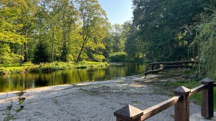 A picturesque corner with green trees and reflection on the water surface.