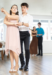 Obraz premium Young couples learning to dance latin american dances in a dance studio