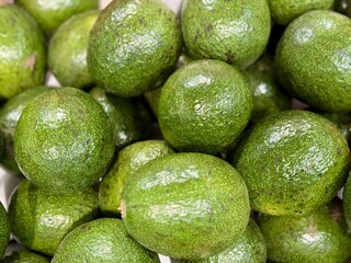 Large rifle green avocados harvested ready to eat are sold on supermarket shelves top view. Healthy eating. Close-up
