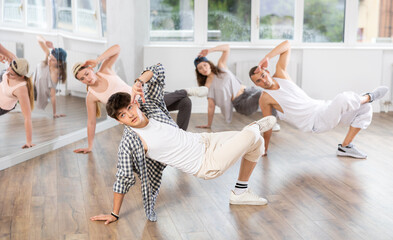 Group of four dancers having break dance training at dance studio
