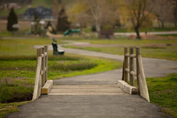 A wooden bridge with a park like blurred background.  No people and a text area.