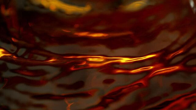 Super Slow Motion Detail Shot of Waving Golden Liquid at 1000fps.