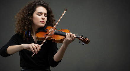 Fototapeta premium Woman Violinist in Studio with Emotional Expression and Curly Hair