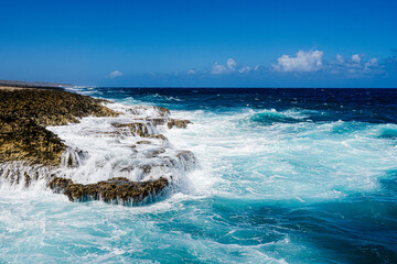 waves crashing on the rocks of the shoreline on island of Curacao in Caribbean 