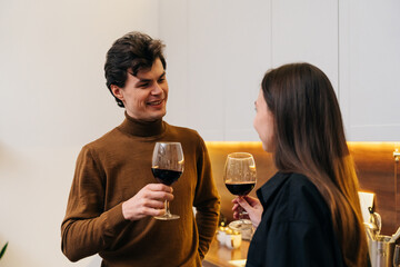 Couple enjoying a cozy evening with red wine in a modern kitchen
