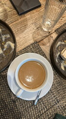 A white cup with a small saucer of coffee.