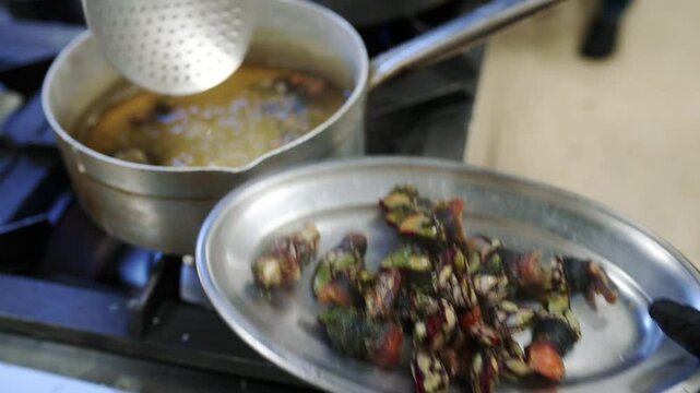Chef cooking goose barnacles in restaurant kitchen