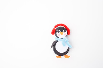 Two black plastic bottle caps transformed into a penguin craft with earmuffs, scarf, and colorful details. Perfect for recycling businesses, DIY projects, kids crafts, and eco-friendly initiatives