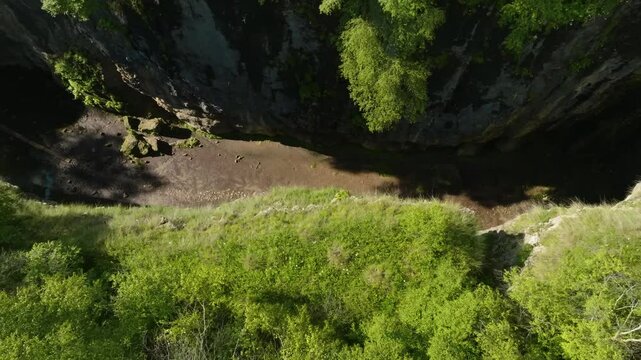 Stunning aerial view of Maltas Canyon, Dagestan, featuring moss-covered mountains, alpine trees, a mountain river, and cloud shadows moving across the valley.