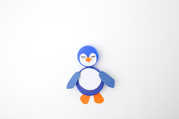 Two blue plastic bottle caps repurposed into a penguin figure with drawn face and paper wings. Perfect for recycling campaigns, kids crafts, and eco-friendly businesses promoting creative upcycling