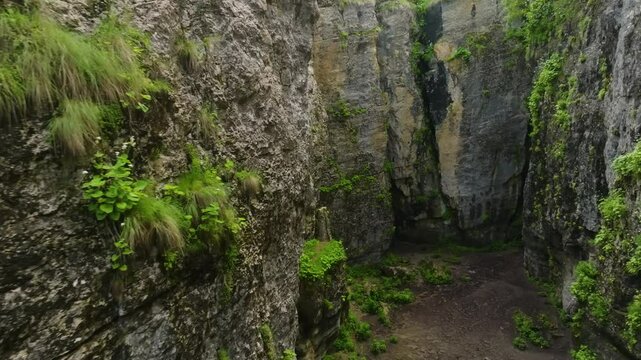 Drone footage of Maltas Canyon, Dagestan, featuring alpine-covered mountains, a winding mountain river, and shifting cloud shadows in golden sunlight.
