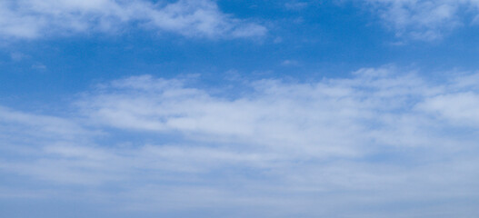 Bright Blue Sky with Soft White Clouds Above