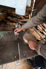 Carpenter Cutting Wood with a Bandsaw in a Rustic Workshop