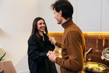 Couple dancing joyfully in a modern kitchen during a cozy evening together