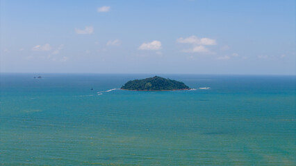 Aerial view of Ilha Feia, a small island off the coast of Balneário Piçarras, Santa Catarina, Brazil, surrounded by the blue waters of the Atlantic Ocean. © Marcio Eneas