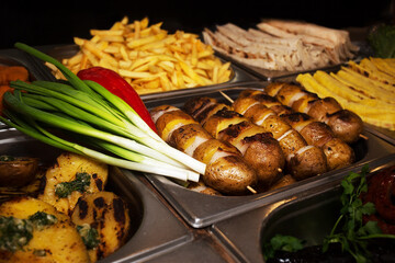 Varied assortment of hot ready-made dishes cooked on the grill. Fast food. Street food to go.