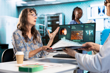 Old woman patient discussing with medic about MRI test results and other health records, examining...