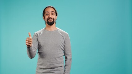 Cheerful man showing thumbs up sign gesturing, exulting happy facial expression and satisfaction....