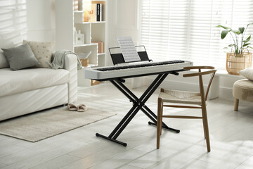 Synthesizer with music sheet and chair at home