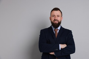 Handsome bearded man in suit on grey background. Space for text