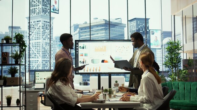 In a multinational company, advisory board meeting to discuss global strategies and work on finance planning. Managers ensuring the integration of development to drive profitability. Camera B.