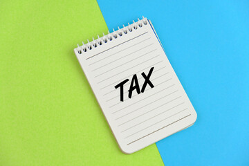 Text of Tax time on yellow note pad as a reminder concept. Notification of the need to file tax returns, tax form at accountant workplace
