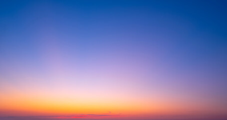 Evening sky background with natural gradient light on colorful orange and blue dusk sky after sundown