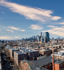 Obraz premium A breathtaking view of Brooklyn showcasing its diverse architecture, from historic brownstones to contemporary buildings, with the iconic Manhattan skyline rising in the background. The contrast betwe