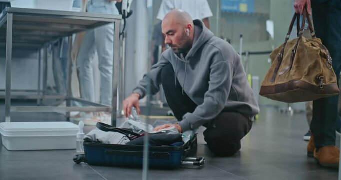 Security Checkpoint in International Airport Terminal: Adult Man Taking Out Liquids from Suitcase. Diverse People, Travelers Going Through TSA Baggage Screening Procedure before Boarding Plane Flight.