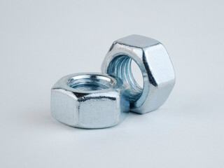 Metal nuts stacked on a light background for hardware use