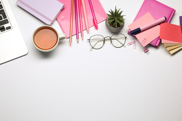 Designer's workplace with stationery, color palettes and cup of tea on grey table, flat lay. Space...