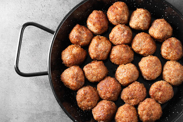 Tasty meatballs in baking dish on grey table, top view