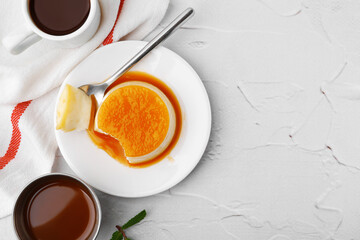 Tasty pudding with caramel sauce served on white textured table, flat lay. Space for text