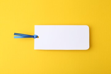 One paper bookmark on yellow background, top view