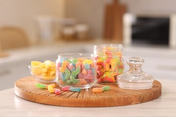 Tasty gummy candies on white table in kitchen