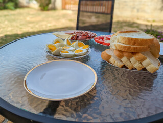 outside eating: Fresh delicious yummy croissant bread,.eggs, ham and tomato salad on the table at garden, breakfast food in the morning