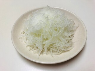 小皿に盛った大根のつま　和食の刺身の付け合せ　大根の細切り