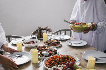 A Few Hands Preparing Foods And Cutlery On The Table For Family Lunch Celebrating Eid Mubarak