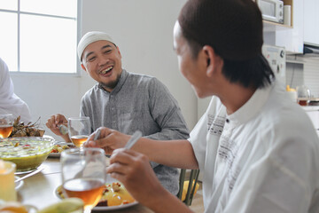 Portrait Of Two Young Brothers Laughing Together Sharing Story While Enjoy Eating Together With Family Celebrating Eid