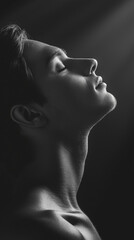 silhouette of a young man, man with a black background, black and white portrait, light and shadow, contrast, meditating person