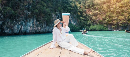 Happy Woman tourist in private longtail boat trip to koh Hong lagoon island at Krabi, Thailand....