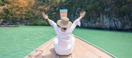 Happy Woman tourist in private longtail boat trip to koh Hong lagoon island at Krabi, Thailand....