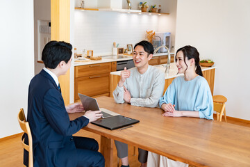提案をするビジネスマンと提案を聞く夫婦