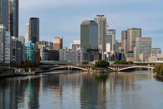 Urban landscape in the area of Temmabashi Station overlooking the Okawa River, Tenjin Bridge and Hachikenyahama Pier in Chuo-ku ward on a sunny autumn day, Osaka, Japan