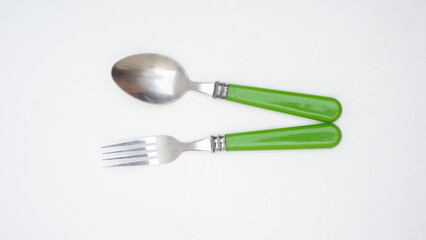 Stylish stainless steel spoon and fork with green handle isolated on white background