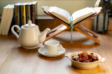 Many Date Palms are on bowls, plates, a cup of water, and the Quran, islamic style lamps on wooden...